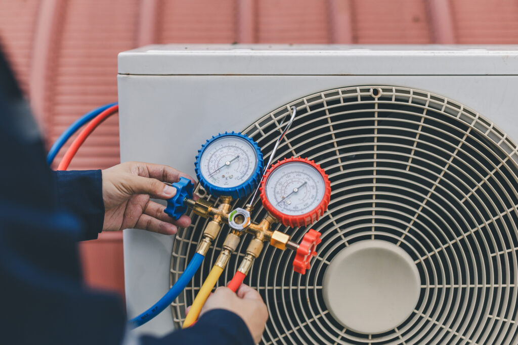 Technician is checking air conditioner Air conditioning, HVAC service technician using gauges to check refrigerant and add refrigerant